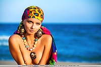 Colorful, vibrant, and enchanting model evoking a sexy sea gypsy by the beach.