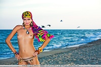 Colorful, vibrant, and enchanting model evoking a sexy sea gypsy by the beach.